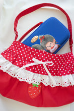 Red fabric shoulder bag with white polka dots, white lace trim, a strawberry applique, and a blue zippered pouch inside.